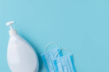 Cerrahi maskeler ve el dezenfektanı ya da mavi arka planda sabun. Sağlık koruma kavramı.