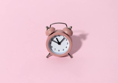 Pastel renkli kâğıt zemin üzerinde fotokopi alanı olan pembe alarm saati. Yaratıcı sabah saati en az tarz konsept şablonu.