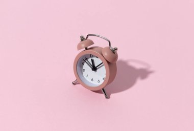 Pastel renkli kâğıt zemin üzerinde fotokopi alanı olan pembe alarm saati. Yaratıcı sabah saati en az tarz konsept şablonu.