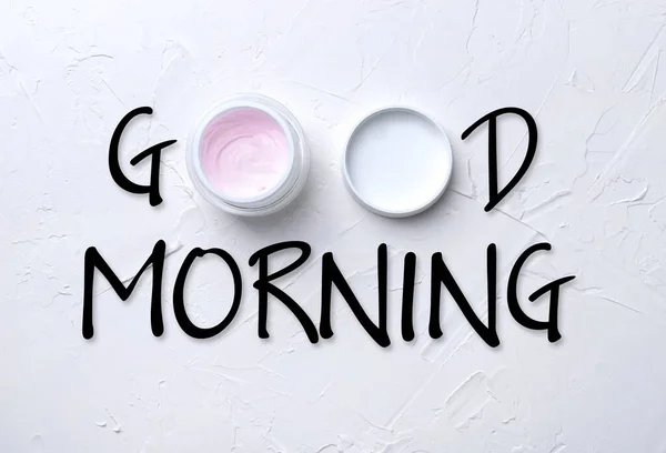 Teks Selamat pagi dan krim kosmetik di latar belakang putih — Stok Foto