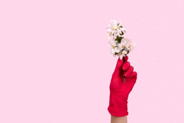 Pembe eldivenli kadın bir çiçek tutuyor. Kendine dikkat et. Evde kal. Karantinada tatil kutlaması