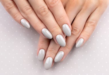 Manikürlü güzel kadın elleri polka noktalı arka planda.