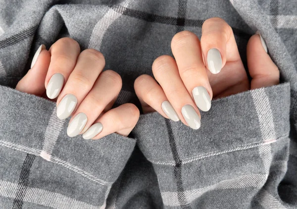 Beautiful womans hand with manicure in checkered shirt — Stock Photo, Image