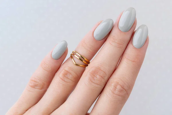 Beautiful womans hand with manicure close up on polka dot background — Stock Photo, Image