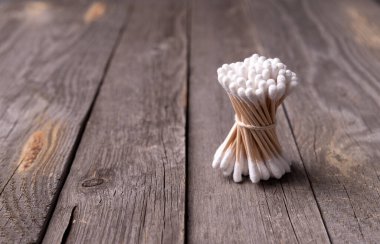 Tahta arka planda bambu pamuk tomurcukları. Sönük tonlar sağlıklı kozmetik ürünleri. Sıfır atık çevre dostu kavram