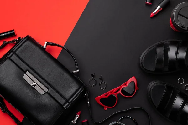 Bolso plano vista superior con accesorios y calzado en doble fondo rojo y negro —  Fotos de Stock