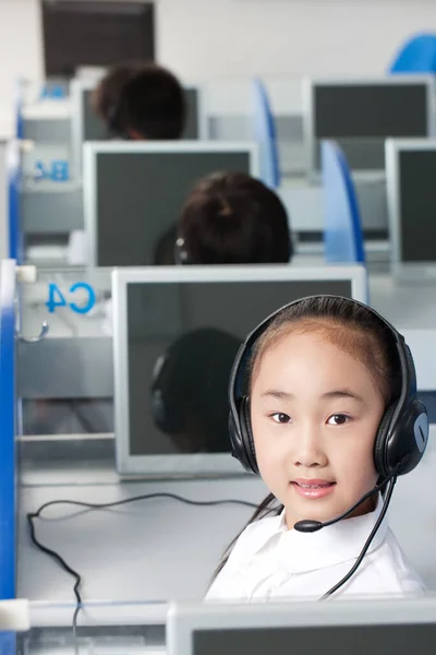 young boy using computer headset at desk in office