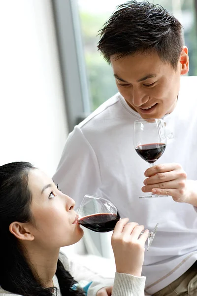 young couple drinking wine and looking at each other