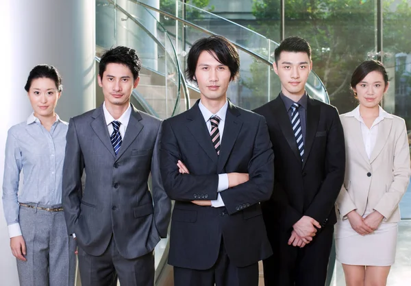 business team standing in front of office building