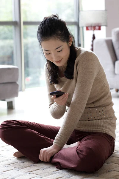 young woman sitting on sofa and reading book