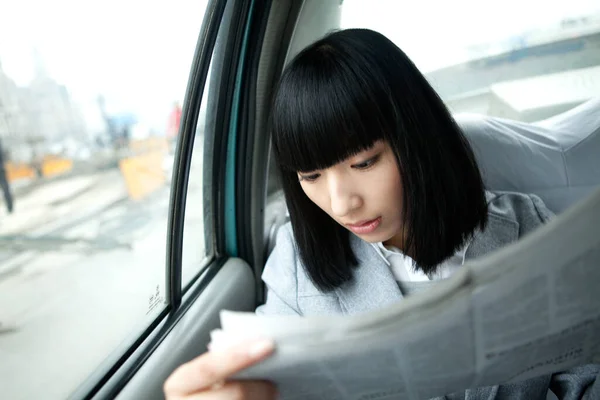 woman reading a book in the car