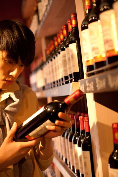 young man with wine bottles in the store