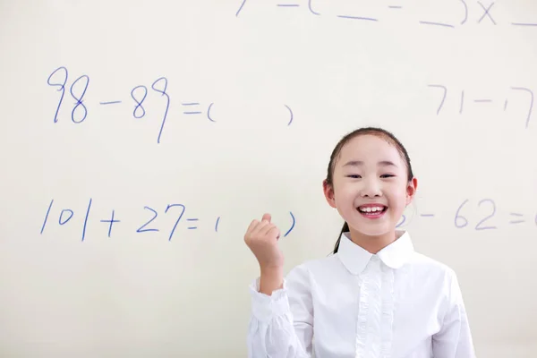 cute little boy writing on the blackboard