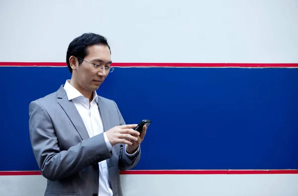 young asian man with mobile phone and smartphone
