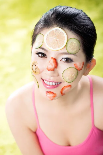 portrait of a beautiful woman with a healthy face mask and a cucumber