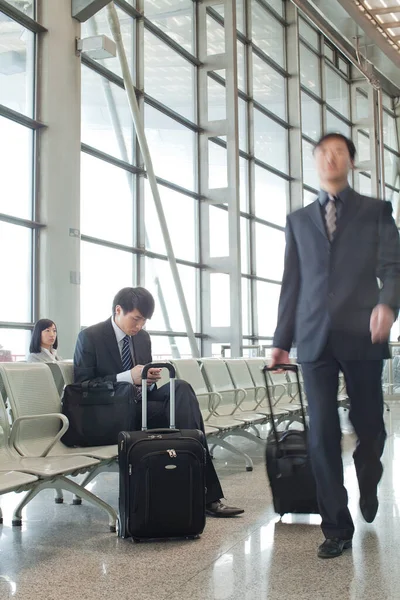 young man and woman in suit with suitcase in airport