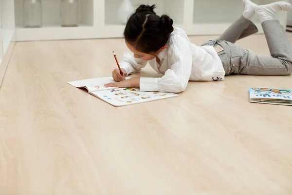 young woman writing on paper with marker on canvas
