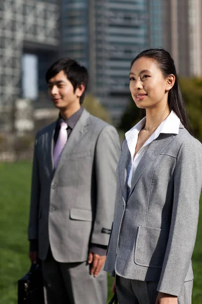 business people standing in front of office building