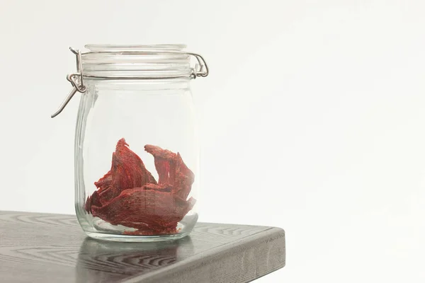 dried fish in glass jar on white background