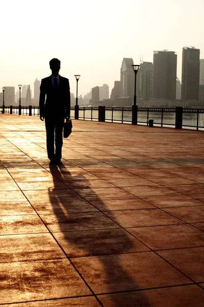 silhouette of businessman walking on the bridge