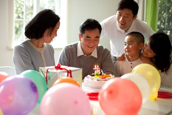 family celebrating birthday with cake at home