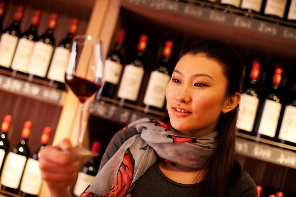 young woman with wine and glass of red grapes in the bar