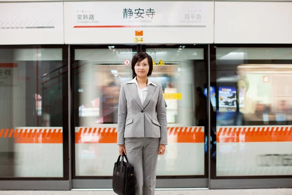 young woman in a suit with a suitcase in the airport