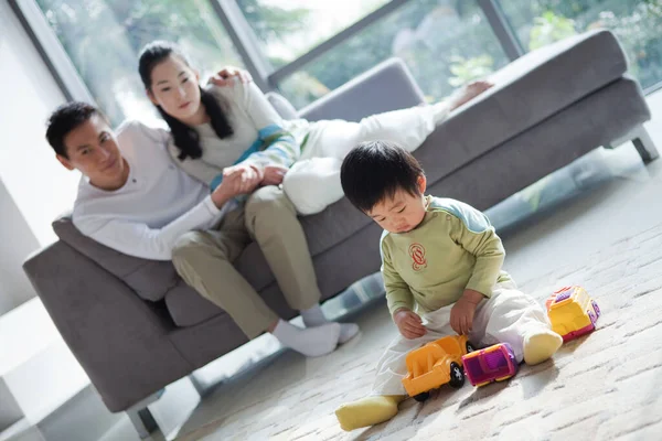 happy family playing with their little son in the living room