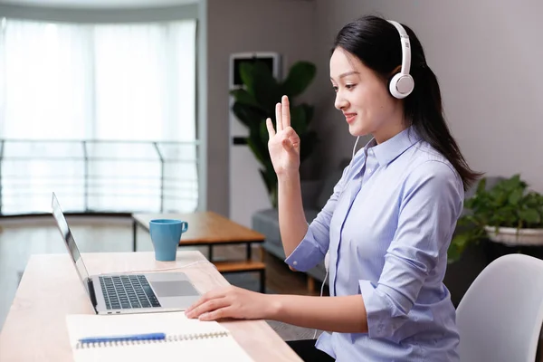 young woman listening music with headset in office