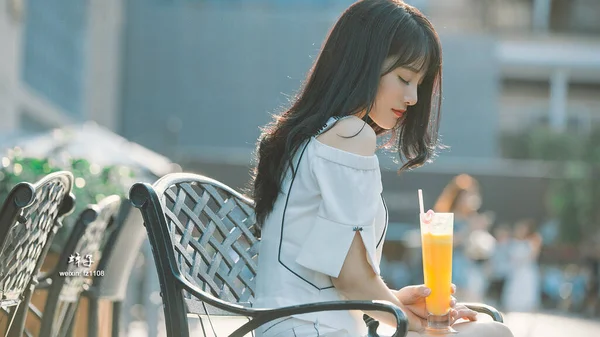 beautiful young woman with cocktail in cafe