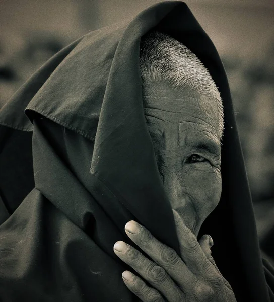 old man in a black suit with a mask