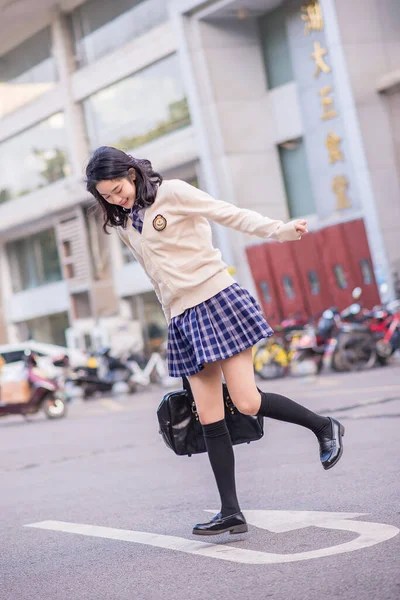 young beautiful woman in a dress and a jacket on the street