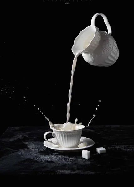 pouring water from a cup on a black background