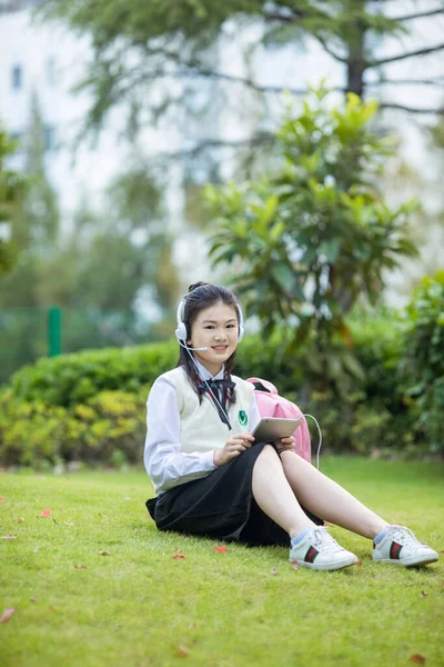 young woman student listening to music with headphones