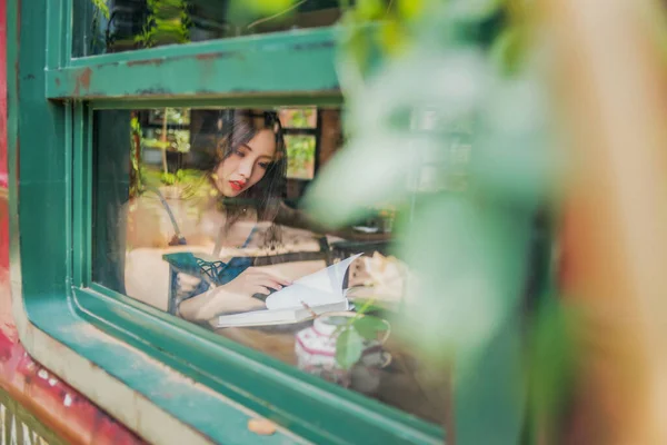 young beautiful woman with a book in the cafe