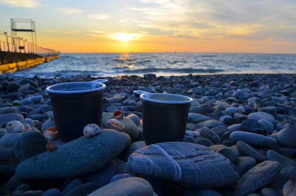 Zwei Tassen Kaffee bei Sonnenuntergang am Meer lizenzfreie Stockbilder