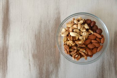 Cam bir tabakta fındık karıştır. Ahşap arka plan. metin için yer