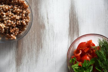 Cam tabakta pişmiş karabuğday lapası. Mesajlaşmak için bir yer var. Salgın hastalığın en popüler ürünü. En sağlıklı ve vitamin zengini lapa. Sebzeli tabak. salata