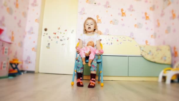 Girl Sitting Chair Playing Doll — Stock Video