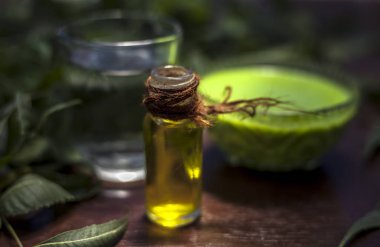 Çok amaçlı Ayurvedic şifalı bitkinin saç ilacı. Neem ya da Nim ya da cam bir kasede Hint leylağı ve kepek için tatlı su ve çay ağacı yağı..