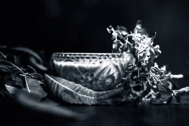 Tulsi, fesleğen, neem ya da Hint leylağı ezmesi ile kahverengi ahşap bir yüzey üzerinde taze neem ve tulsi yapraklarıyla dolu cam kaseyi yakın çekim yapın..