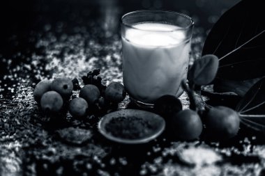 Banyan meyve tozu, şeker ve kimyon tohumlarından oluşan tahtadan yüzeyde erken boşalma için en iyi ayurvedic ilaç bardağa karıştırılmış. Tüm malzemelerin fotoğrafını çektim..