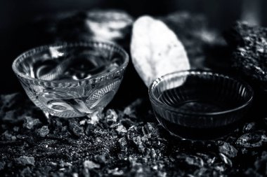 Banyan ağaç kabuğu tozu ile su ve bal karışımından oluşan siyah parlak bir yüzey üzerinde cinsel yolla bulaşan hastalıklar için ev yapımı bir ilaç. Yatay yüksek açı çekimi.