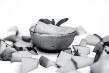 Çiğ patatesle haşlanmış ezmesini ya da püresini cam bir kasede, beyaz bir yüzeyde izole edilmiş nane yapraklarıyla yakın çekim yap. Yatay çekim.