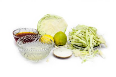 Beyaz üzerine izole edilmiş lahana maskeyi kapat. İçine biraz lahana ezmesi karıştırılmış yumurta, bal, pirinç tozu ve cilt iltihabı ve enfeksiyon önleyici limon koyulmuş bir kâse..