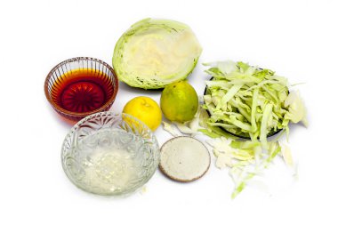 Beyaz üzerine izole edilmiş lahana maskeyi kapat. İçine biraz lahana ezmesi karıştırılmış yumurta, bal, pirinç tozu ve cilt iltihabı ve enfeksiyon önleyici limon koyulmuş bir kâse..