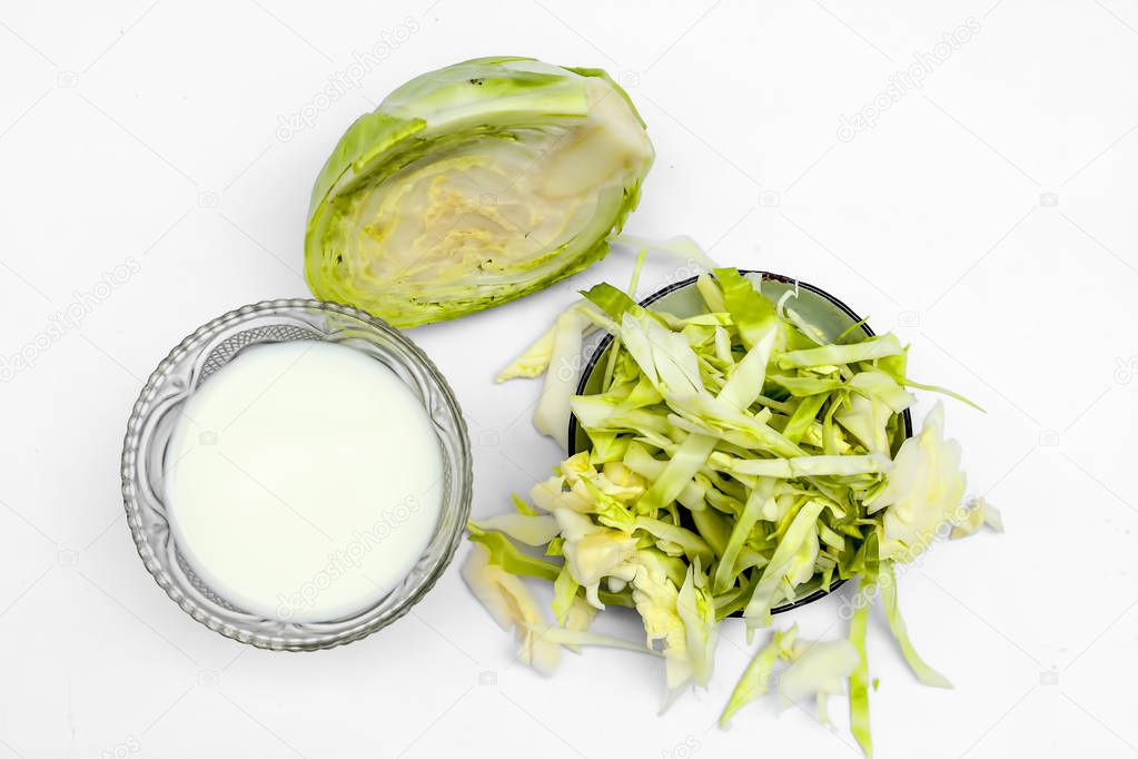 Close up of cabbage face mask isolated on white. Horizontal shot of a bowl with some cabbage pulp well mixed with milk. Used to bleach and hydrate skin.