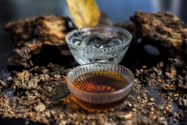 Banyan ağaç kabuğu tozu ile su ve bal karışımından oluşan siyah parlak bir yüzey üzerinde cinsel yolla bulaşan hastalıklar için ev yapımı bir ilaç. Yatay yüksek açı çekimi.