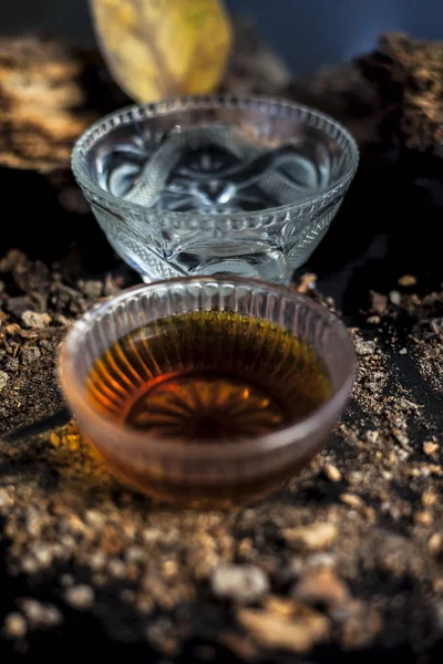 Banyan ağaç kabuğu tozu ile su ve bal karışımından oluşan siyah parlak bir yüzey üzerinde cinsel yolla bulaşan hastalıklar için ev yapımı bir ilaç. Dikey çekim.