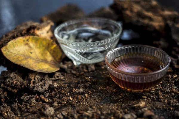 Banyan ağaç kabuğu tozu ile su ve bal karışımından oluşan siyah parlak bir yüzey üzerinde cinsel yolla bulaşan hastalıklar için ev yapımı bir ilaç. Yatay yüksek açı çekimi.